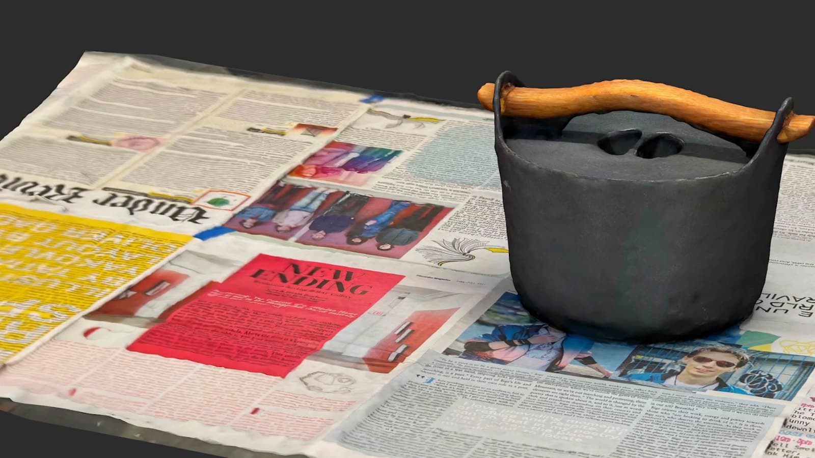 A 3D scan of a cast iron pot standing on a spread of newspaper.